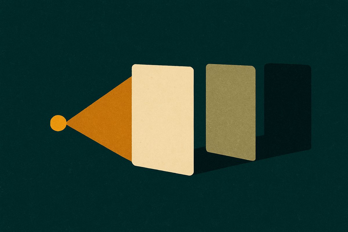 A single small amber light on a dark teal field throws a cone of light that reaches exactly one cream card, lighting it fully; two more cards of the same shape stand just beyond the beam, one dim and one almost black, with the first card casting a long shadow across them
